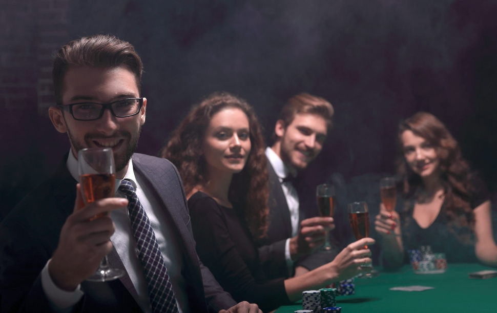 poker players with a glass of wine ,sitting at a table in a casino